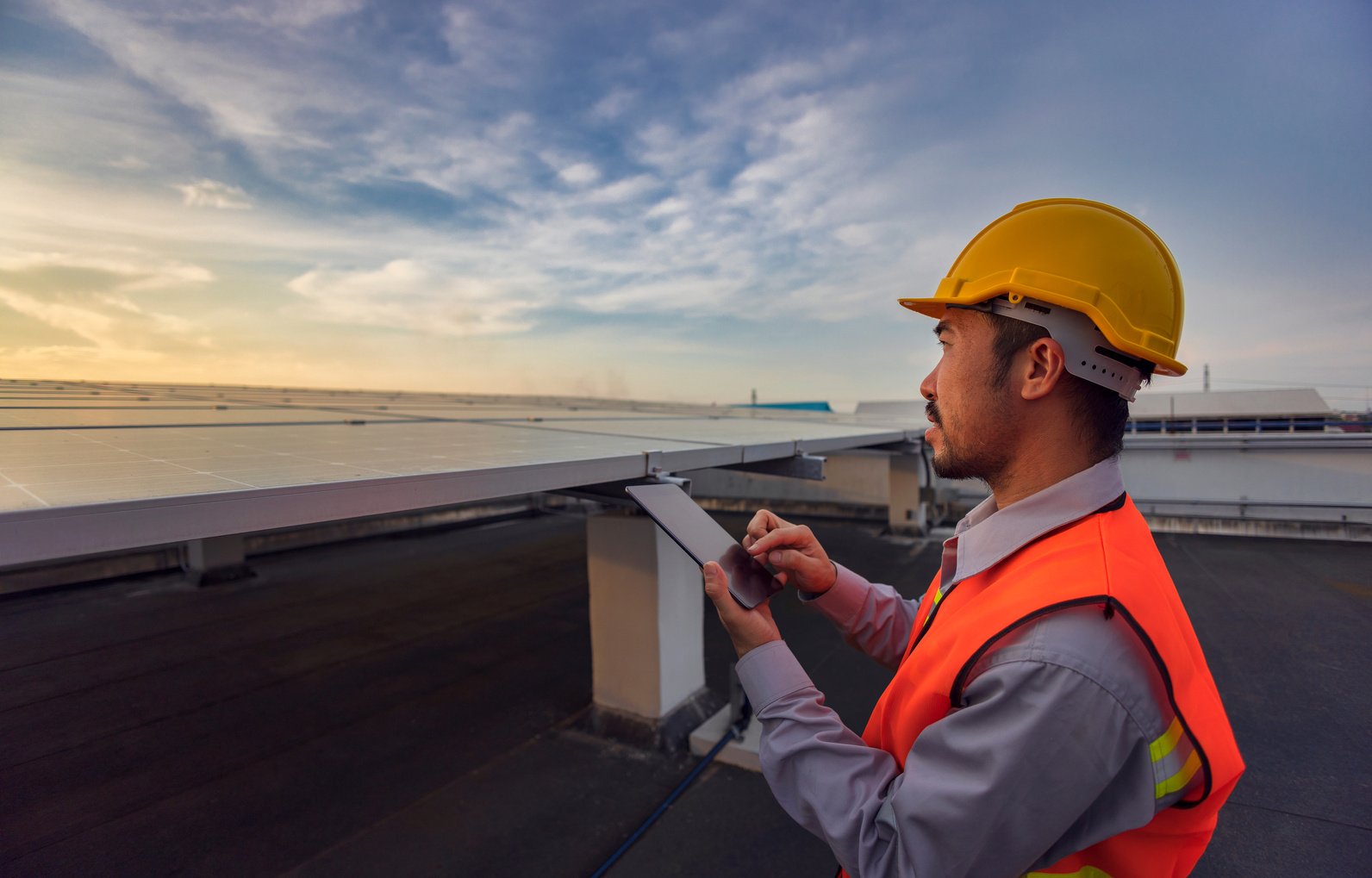 Engineers Use a Tablet to Work on Roof Inspection and Maintenanc